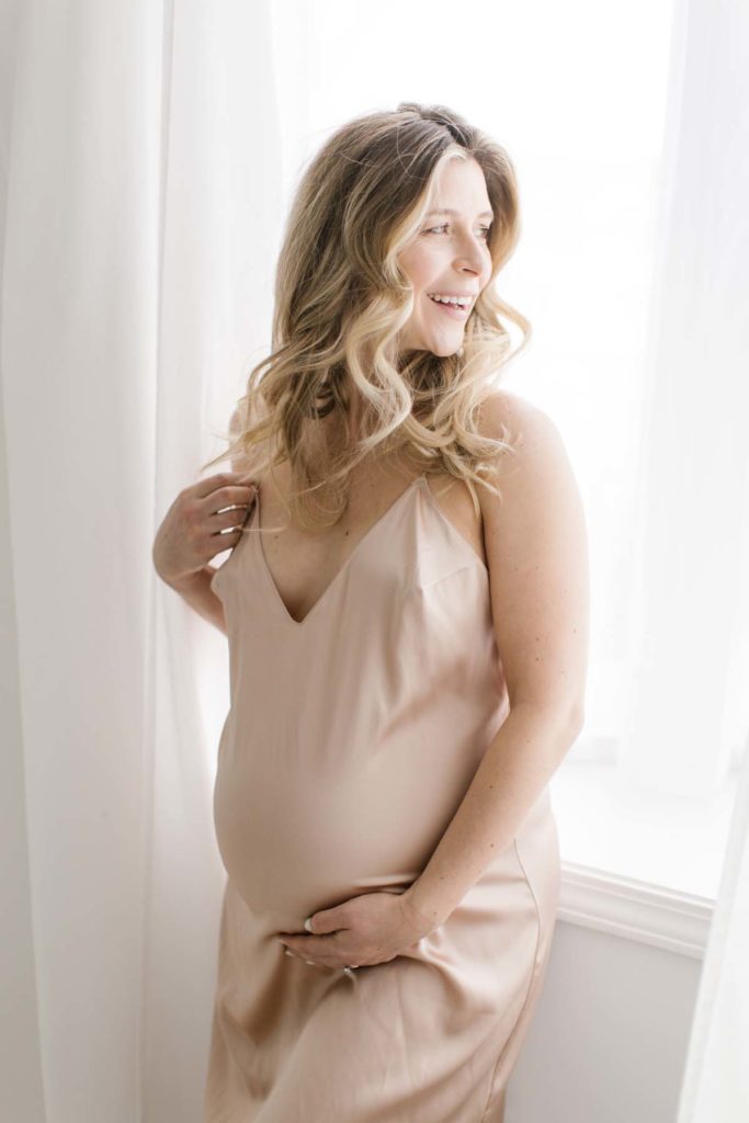 woman laughing during pregnancy photography session