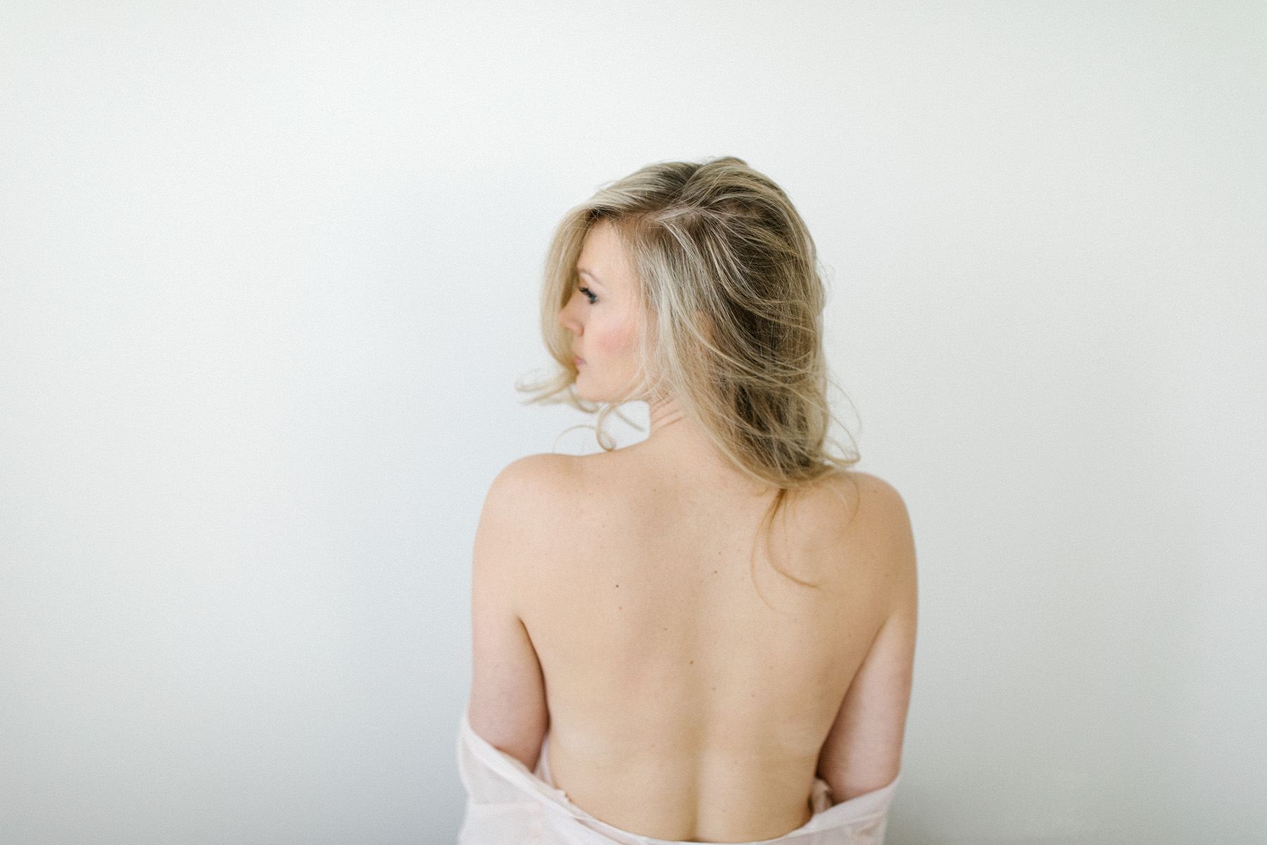 woman showing her back during bridal boudoir session | Boudoir by Elle