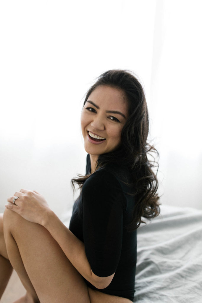 natural boudoir photo of a woman laughing during forty and fabulous session